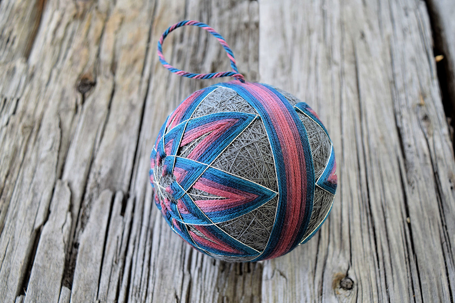 Pink and blue temari ball ornament showing obi band and kiku design