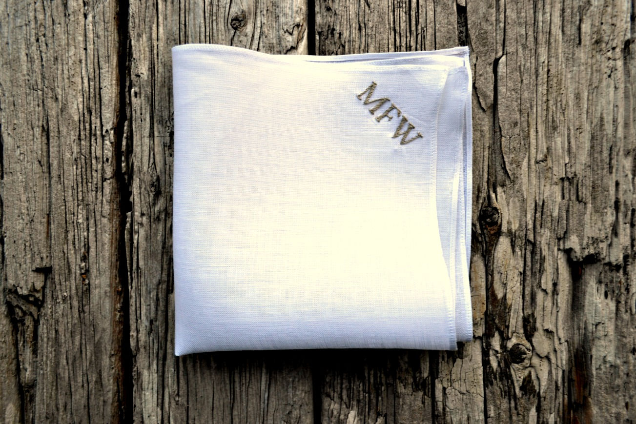 Closeup of white linen handkerchief showing hand embroidered letters MFW in grey