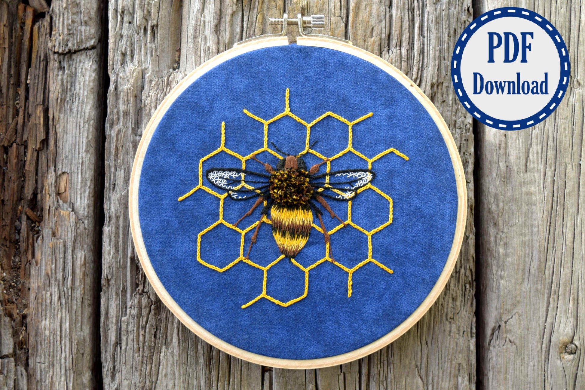 Fuzzy hand embroidered bee in yellow and black on blue background fabric