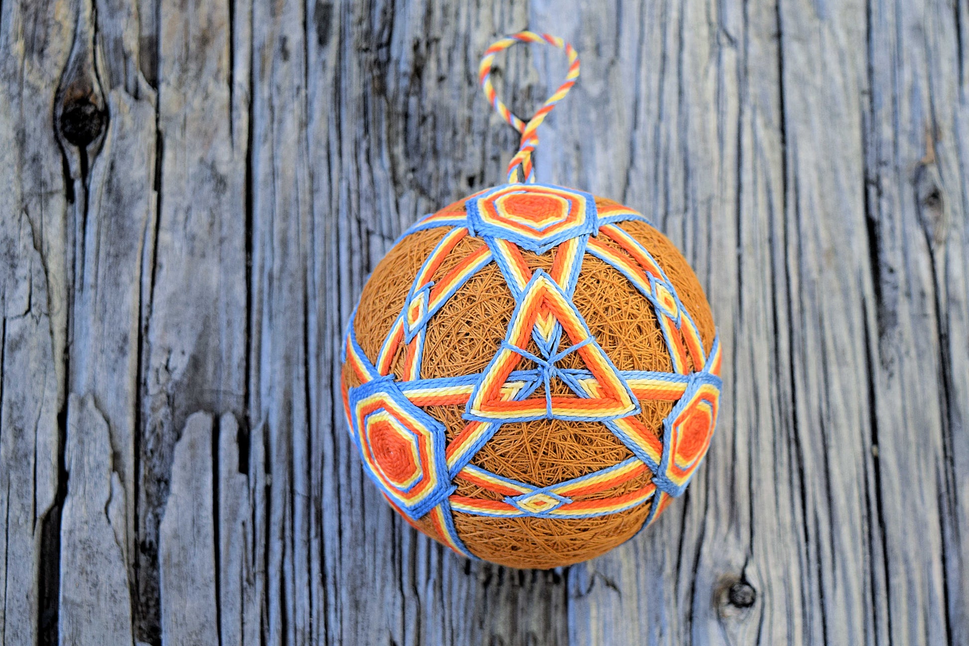 Japanese temari ball in orange and blue on wood background