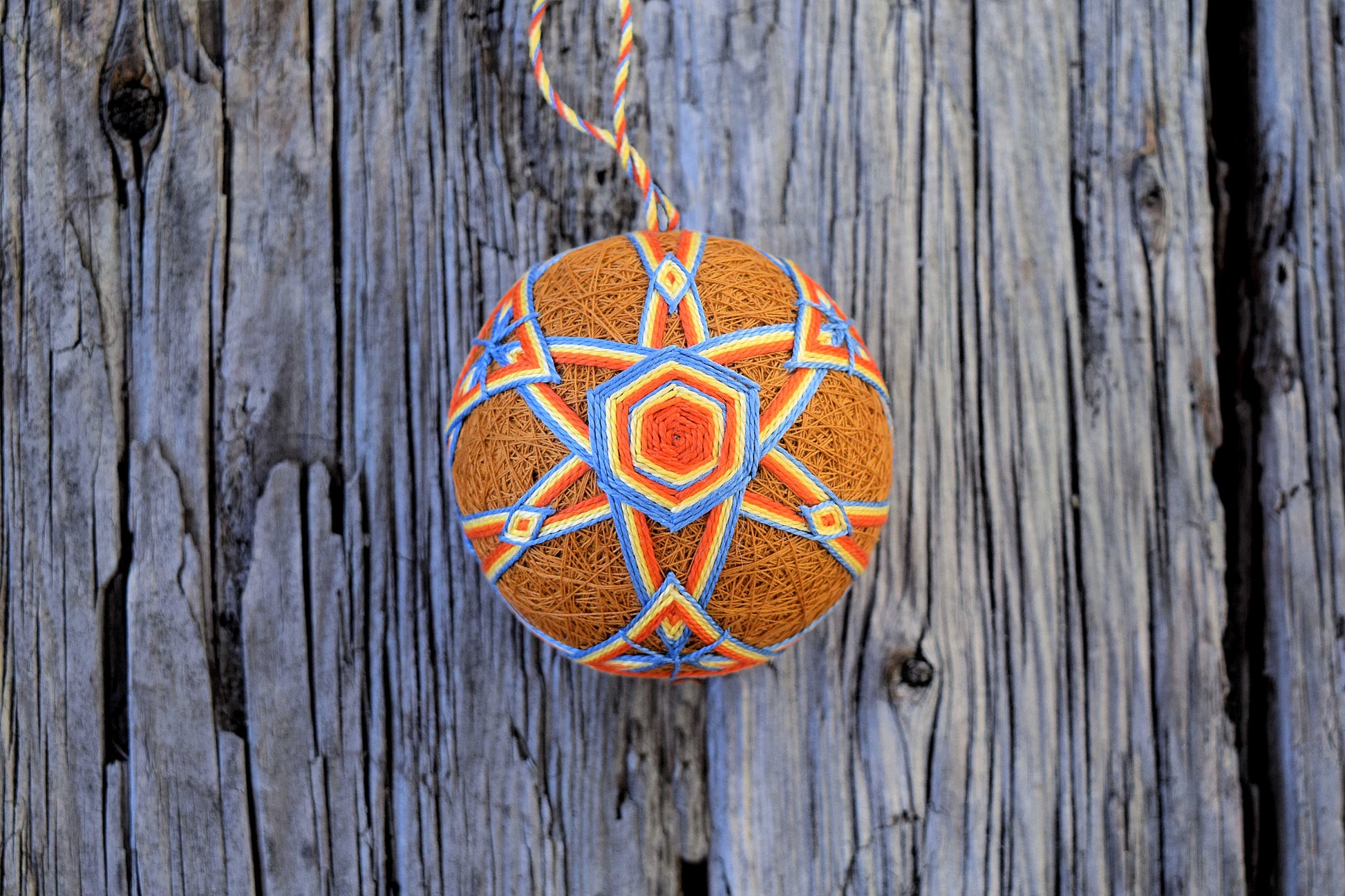 Japanese temari ball in harvest hues on wood