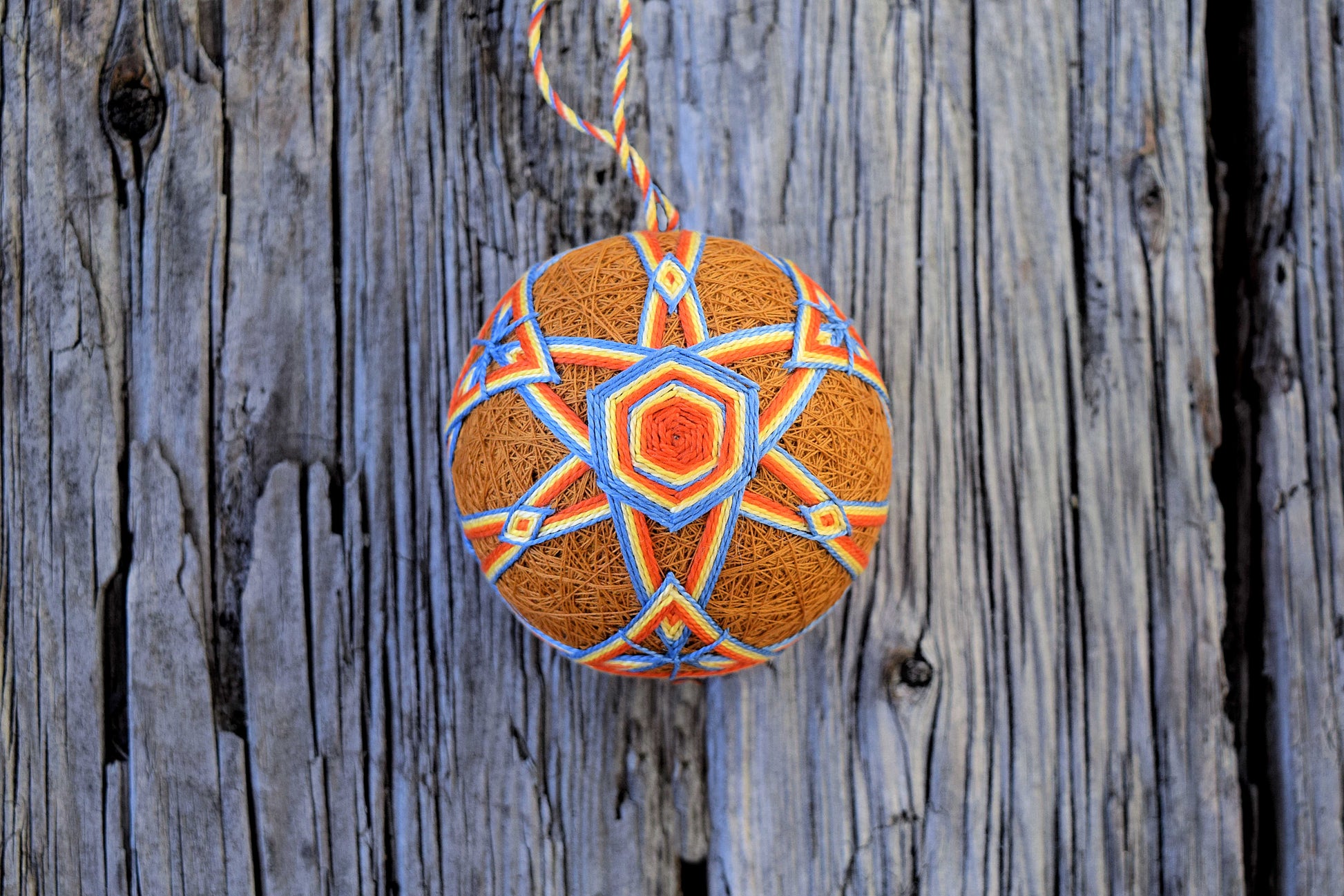 Japanese temari ball in harvest hues on wood