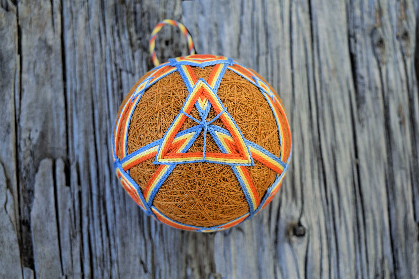 Japanese temari ball with triangles in orange on gold