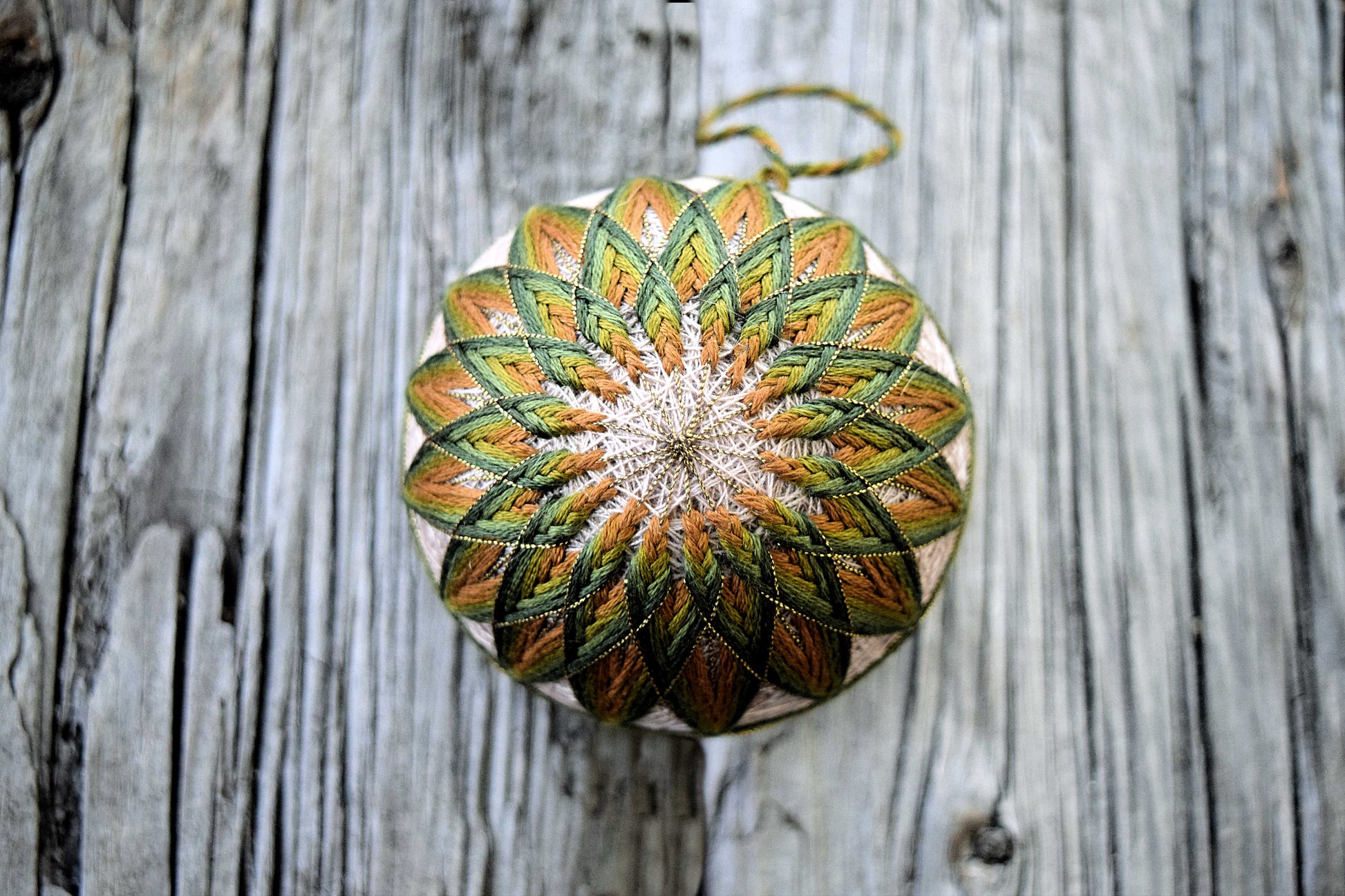 Green and bronze brown Japanese temari on wood background