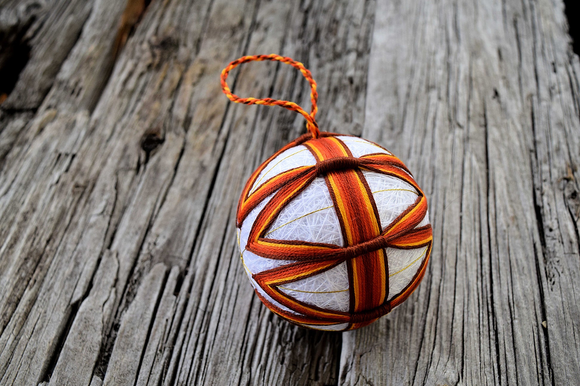 Side view of rust and brown jyouge douji temari showing thread wraps