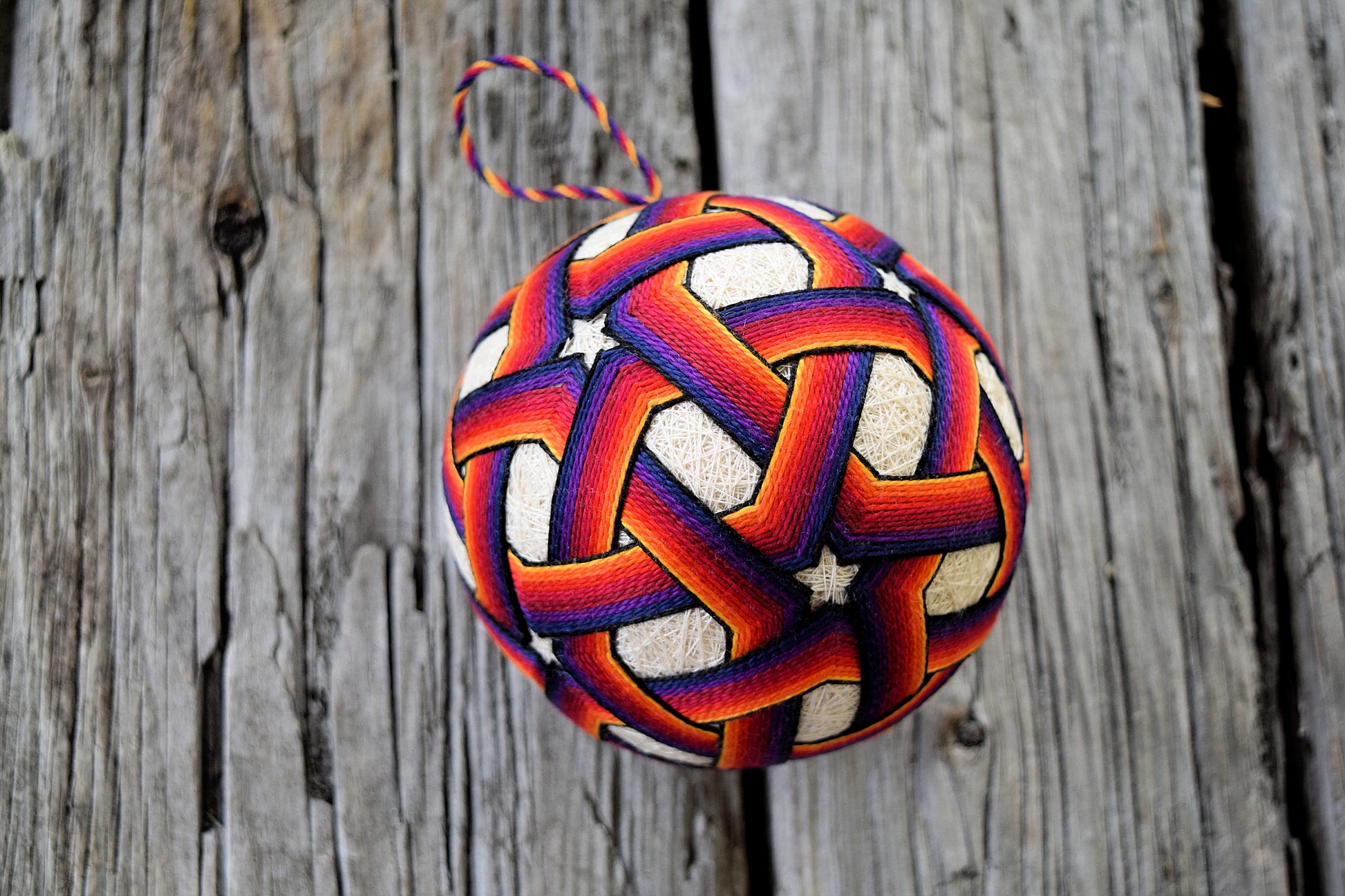 Temari embroidered in deep rainbow tones with stars and triangles