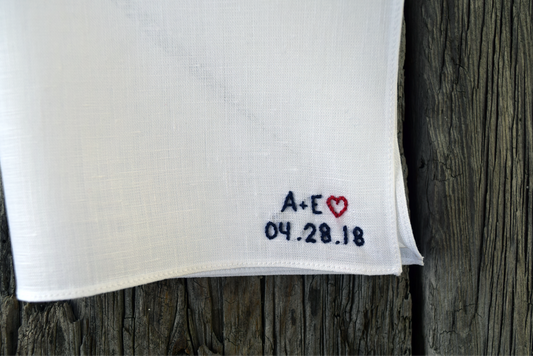 White linen pocket square with initials, heart, and date embroidered in tiny letters in bottom right hand corner