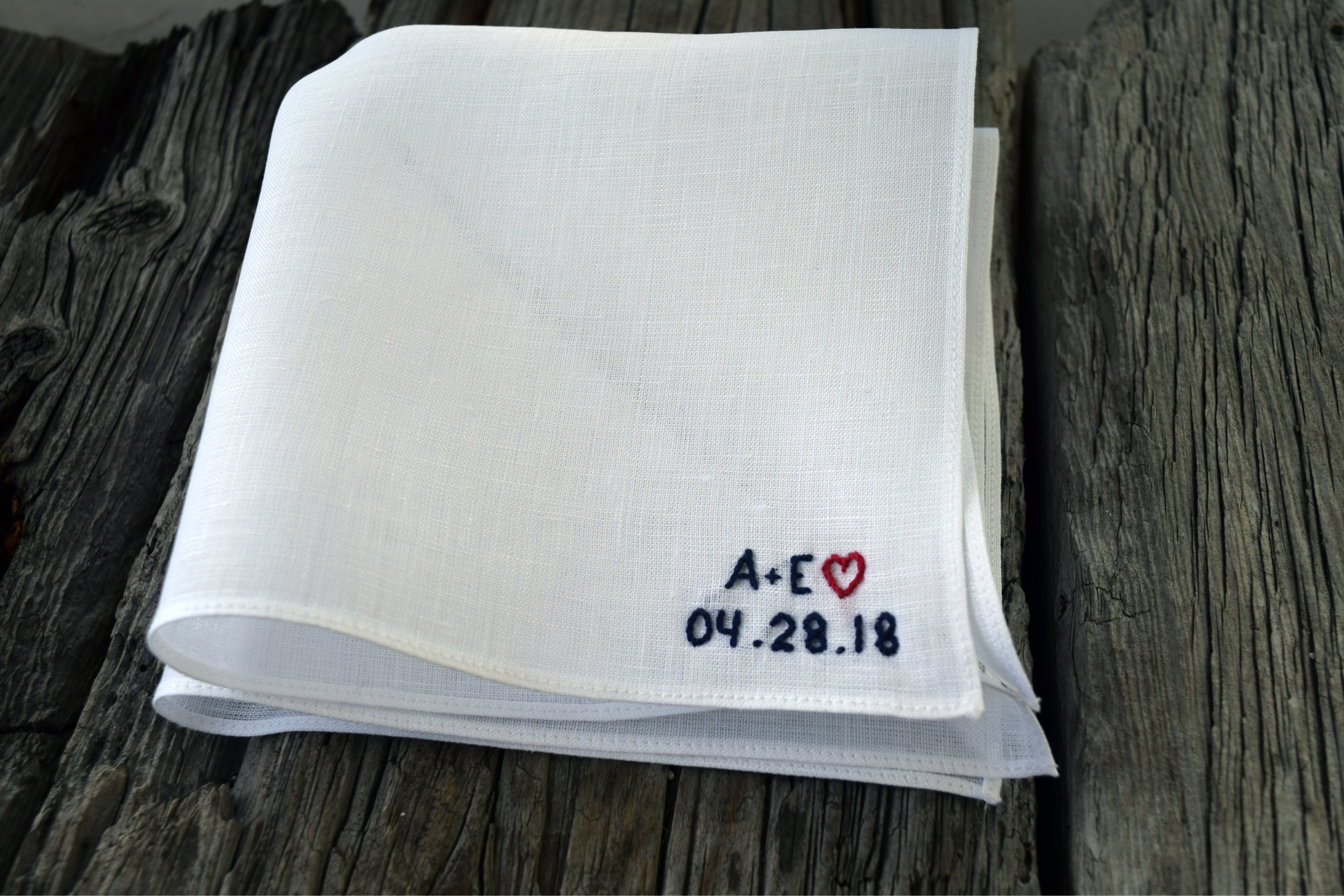 White Irish linen handkerchief hand embroidered with " A + E 04.28.18 " in navy and red