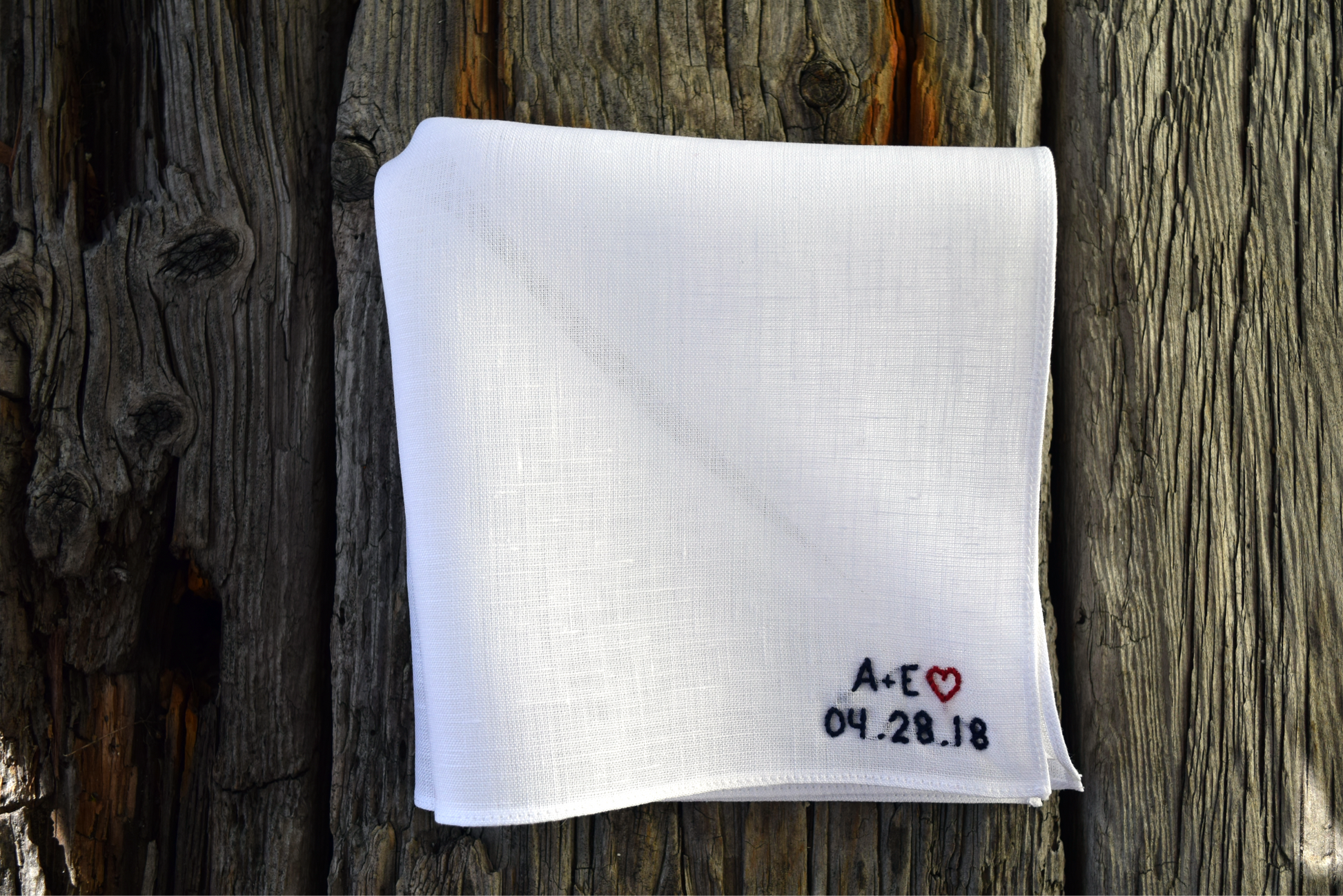 White linen handkerchief hand embroidered with wedding monogram, heart, and date