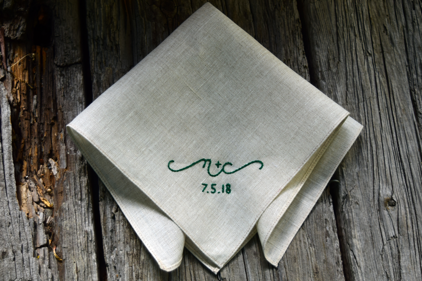 Oatmeal linen handkerchief hand embroidered with 'n + c, 7.5.18' in emerald green