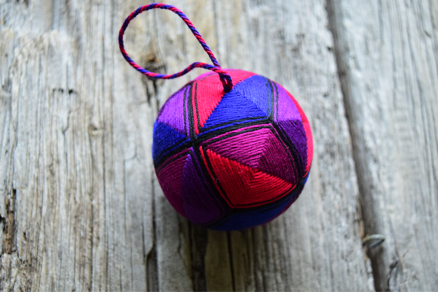 Hand embroidered temari ball in jewel tones with twisted thread hanger. 