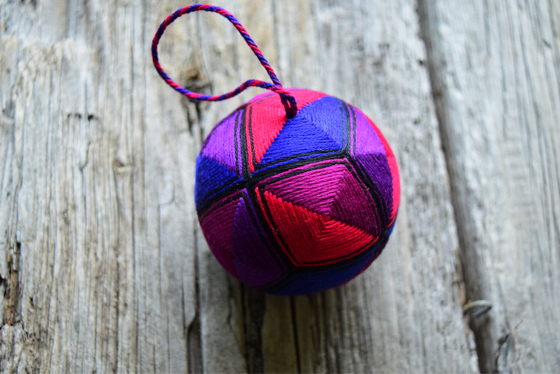 Hand embroidered temari ball in jewel tones with twisted thread hanger. 