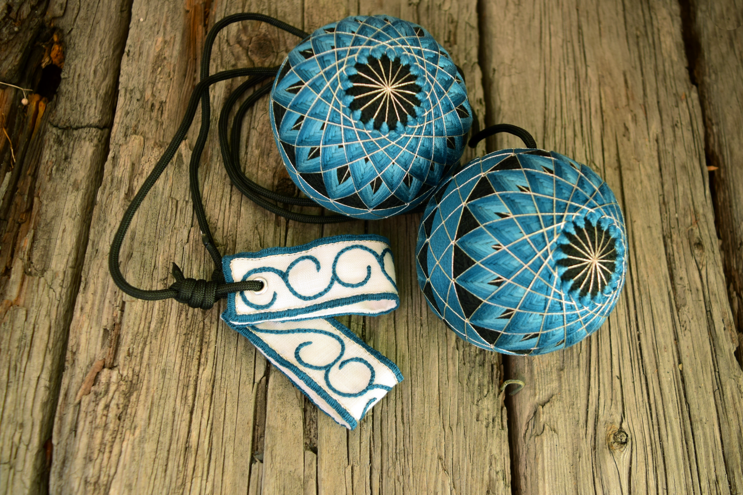 Hand embroidered temari poi in teal and silver on black bases