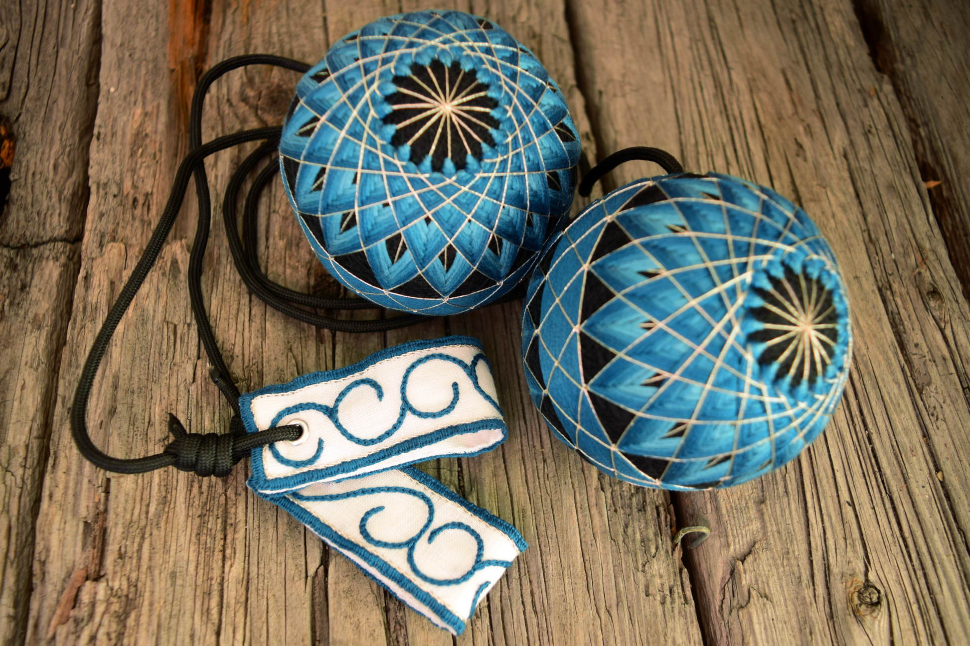 Hand embroidered temari poi in teal and black with swirl handles