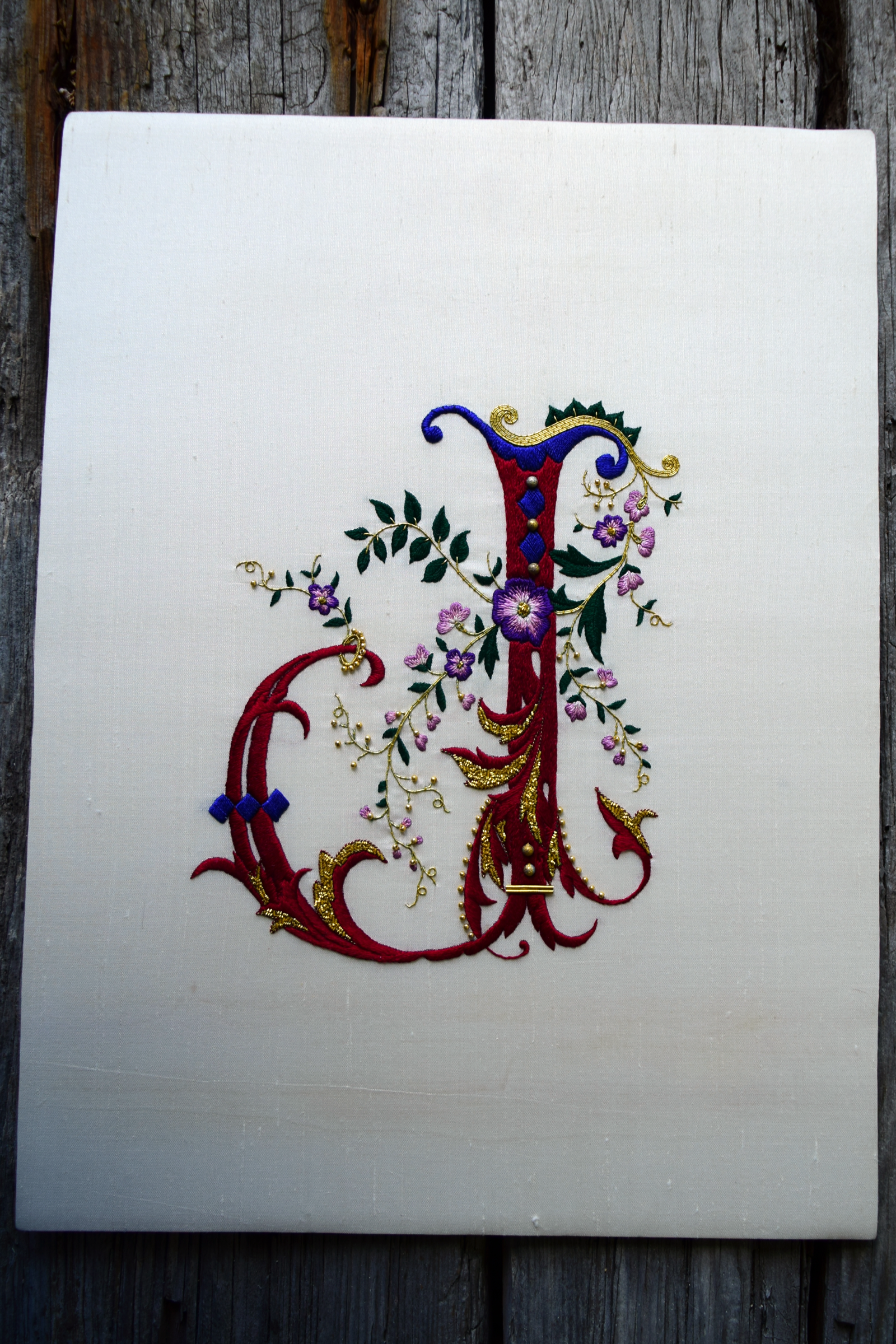 Ornate French gothic letter J worked in silk on cream dupioni, accented with gold metal threads