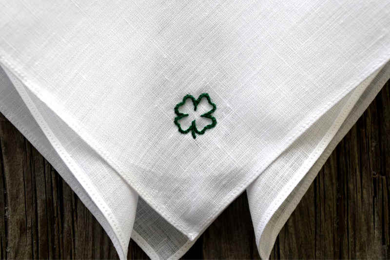 Closeup of white linen handkerchief hand embroidered with a lucky clover