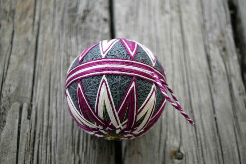 Top view of kiku temari ball showing points of star pattern and thread hanger