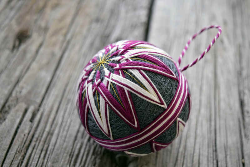 Side view of Japanese temari ball showing striped obi band and kiku design 