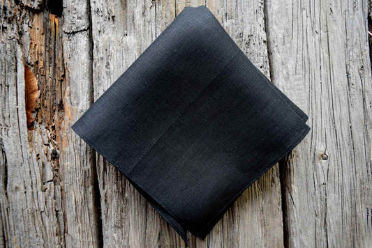 Black Irish linen pocket square on wood background