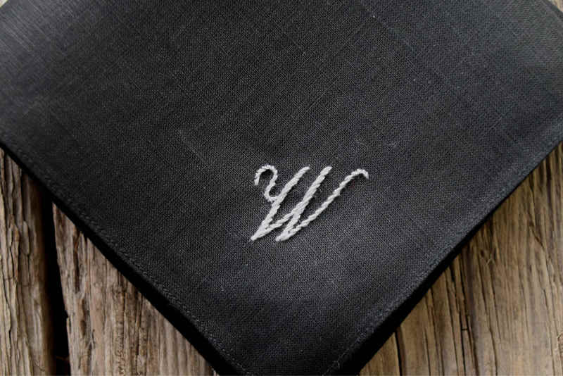 Close up of black linen pocket square hand embroidered with grey letter W
