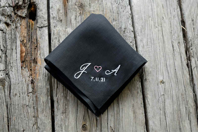 Black linen handkerchief with J (heart) A 7.11.21 hand embroidered in one corner, in white and pink