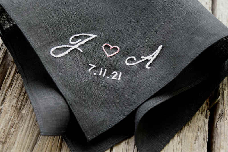 Close up of black linen pocket square with J (heart) A 7.11.21 in white and pink, hand embroidered