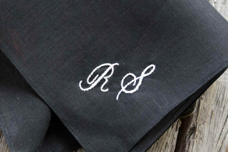 Close up of black handkerchief with RS embroidered in white script in one corner