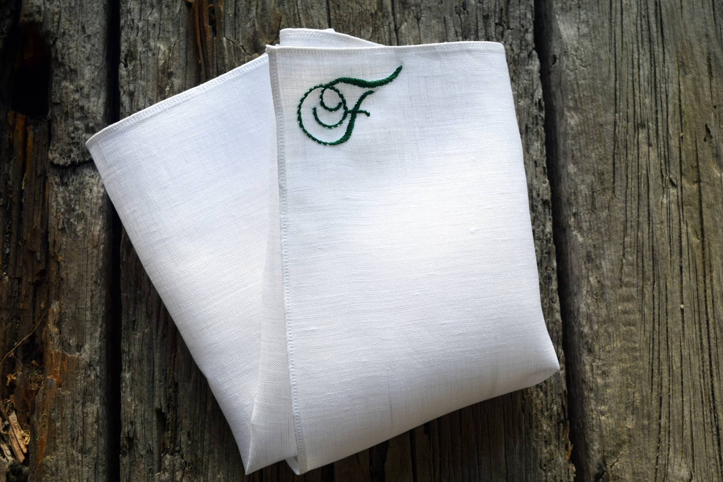 White linen handkerchief with monogram F in top corner in green