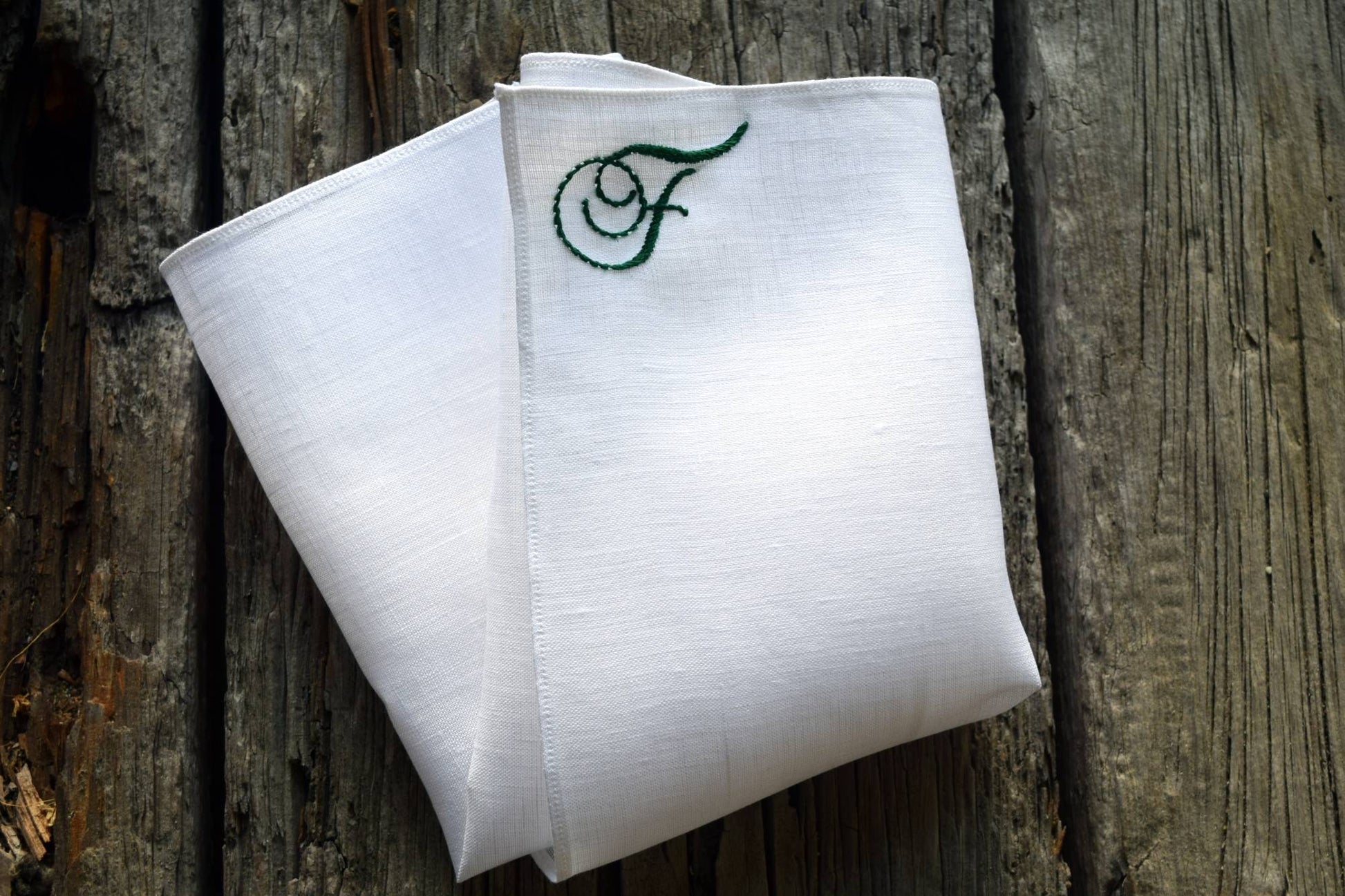 White linen handkerchief with monogram F in top corner in green