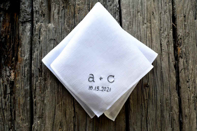 Folded Irish linen handkerchief, white, with two initials and a wedding date embroidered in grey