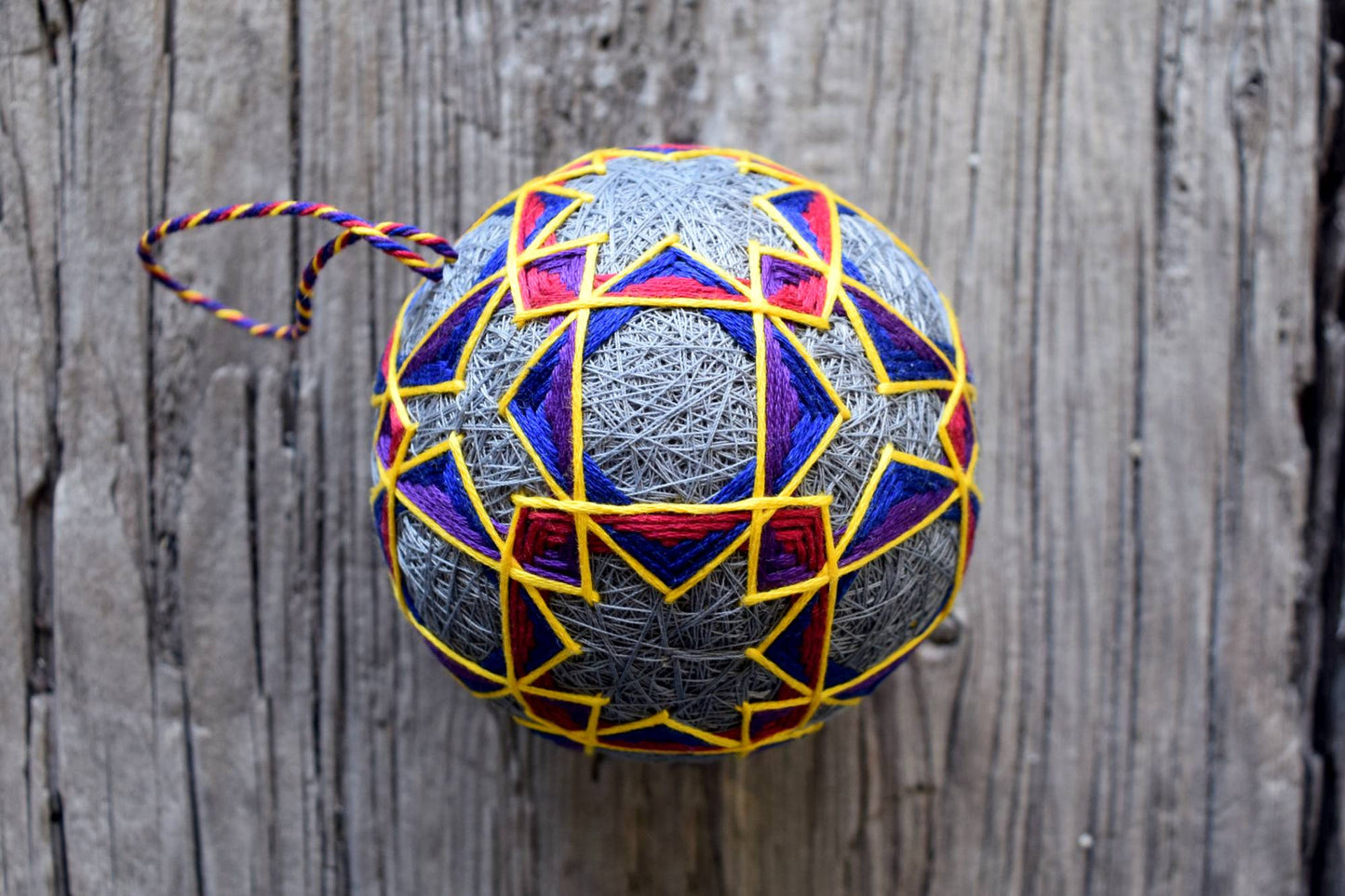 Japanese temari ball top down showing interlocking diamonds and triangles in jewel tones