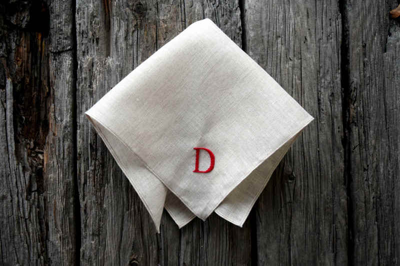 Oatmeal pocket square hand embroidered with letter D in red on wood background