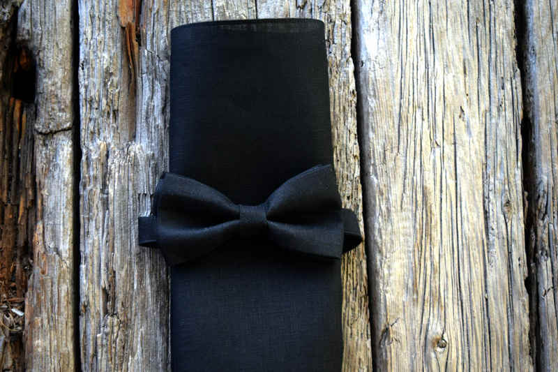 Black Irish linen pocket square folded into a narrow rectangle and wrapped with a bow tie made from the same matterial