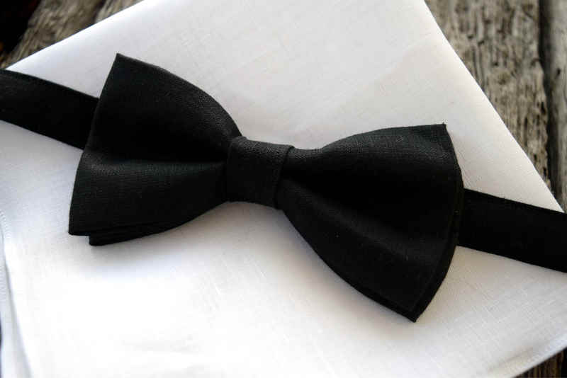 Closeup of black linen bow tie on top of white linen handkerchief, showing texture of linen