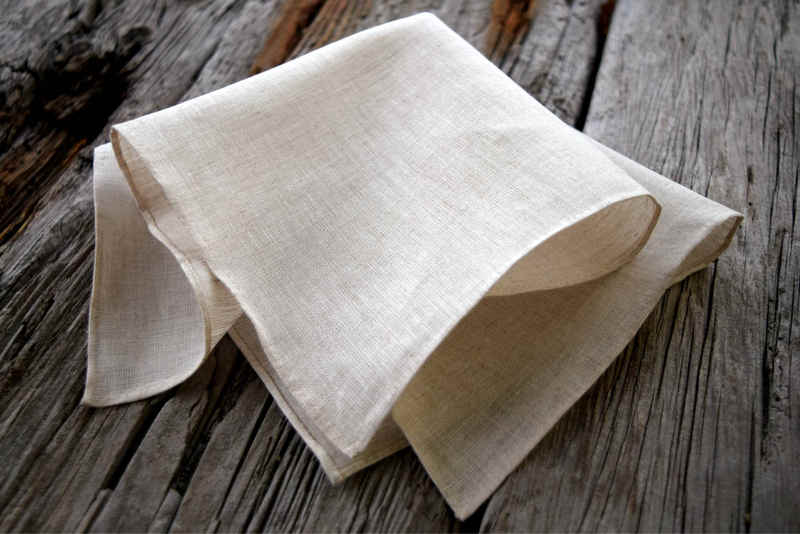 Closeup of oatmeal colored linen handkerchief with hand rolled hem