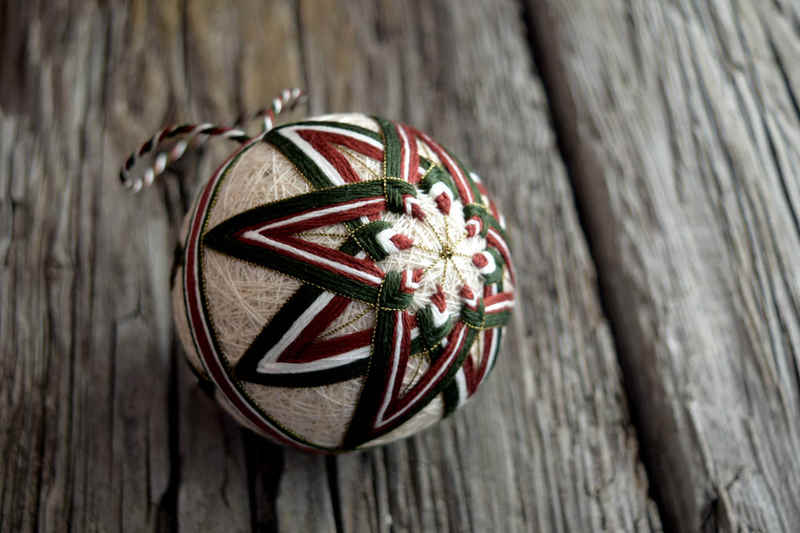 Japanese temari ball embroidered in green and brown in eight-pointed star design