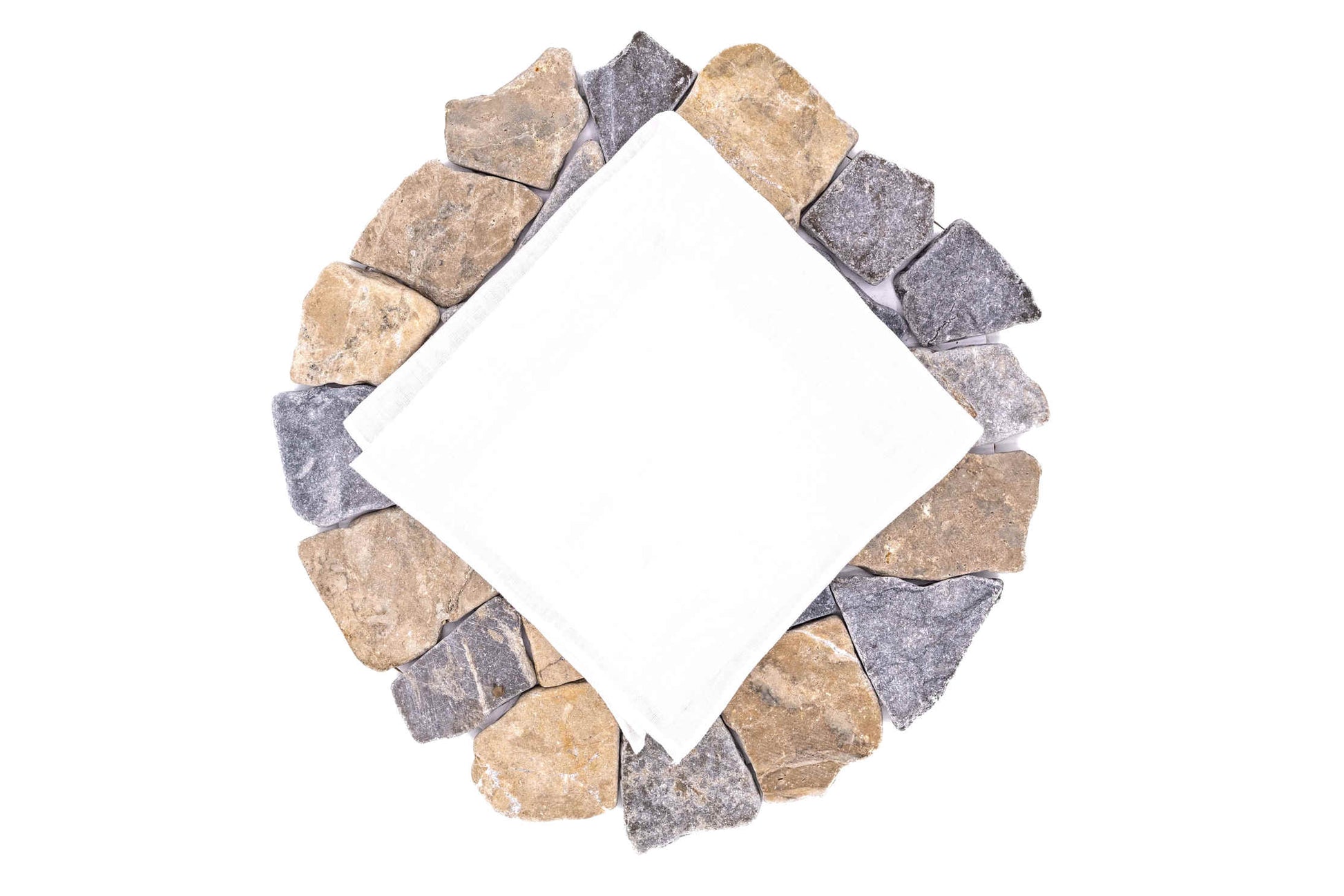 White linen handkerchief folded on a circle of stones.