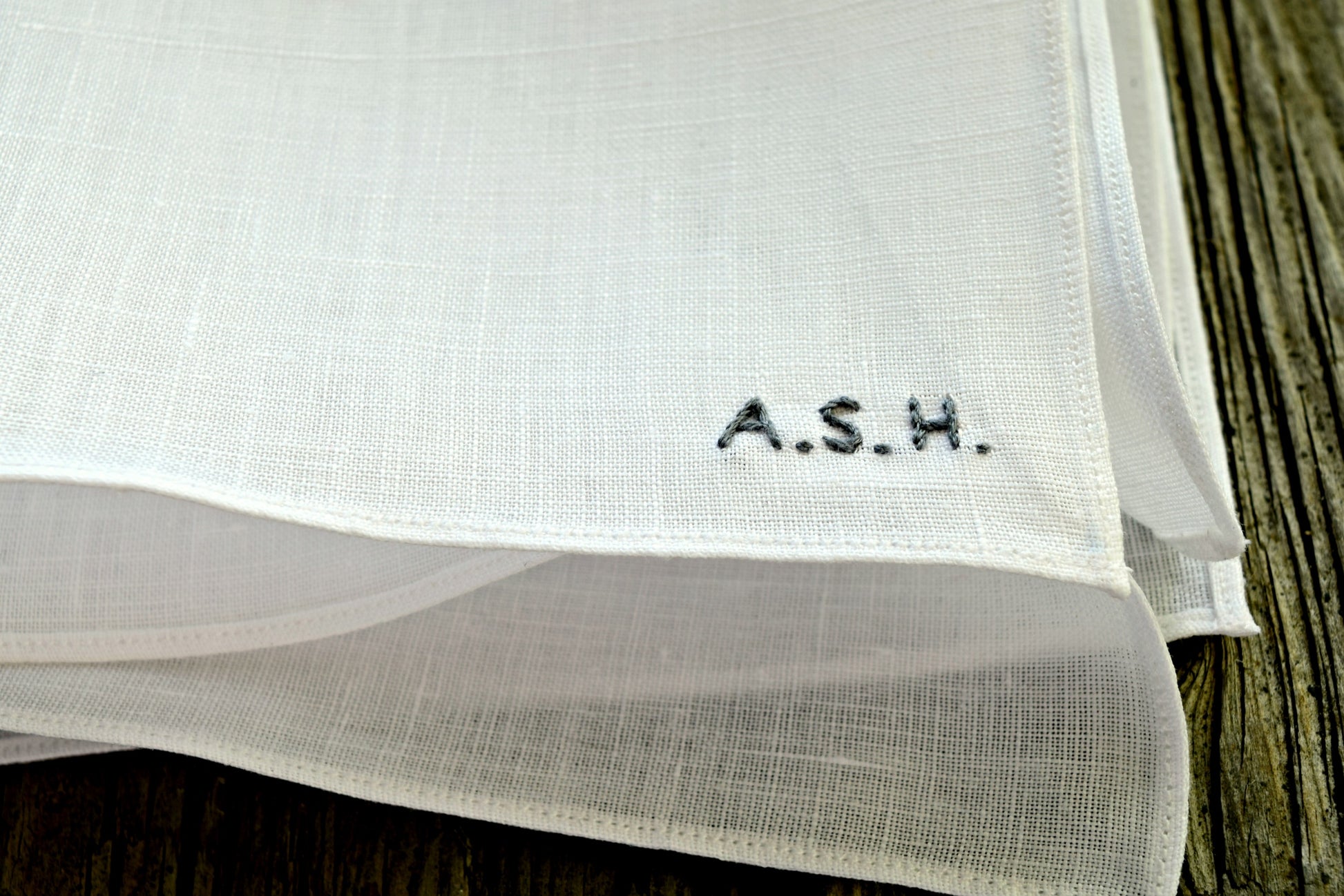 Closeup of white handkerchief showing minimalist initials detail