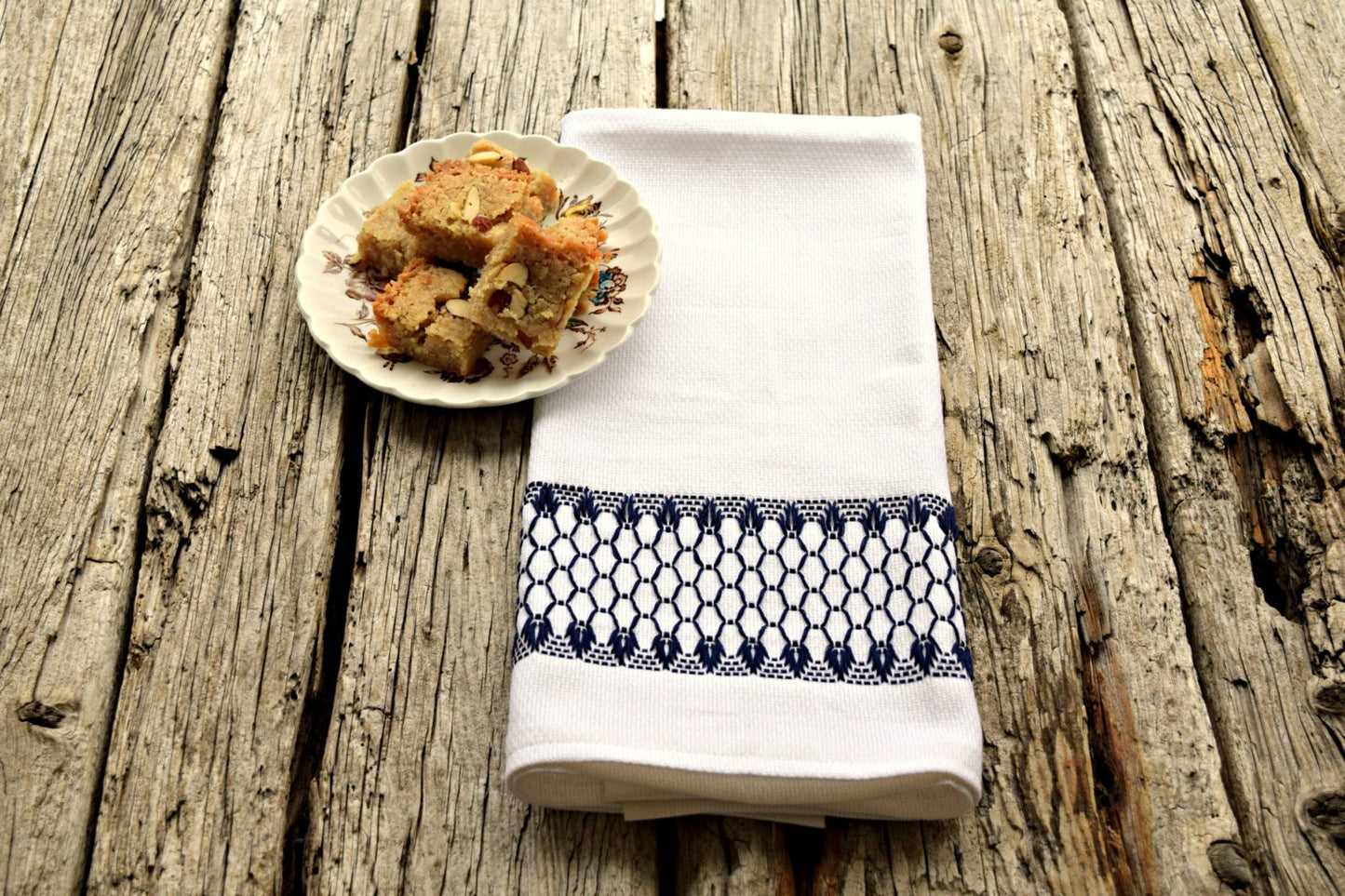 Huck tea towel hand embroidered in navy with plate of cookies