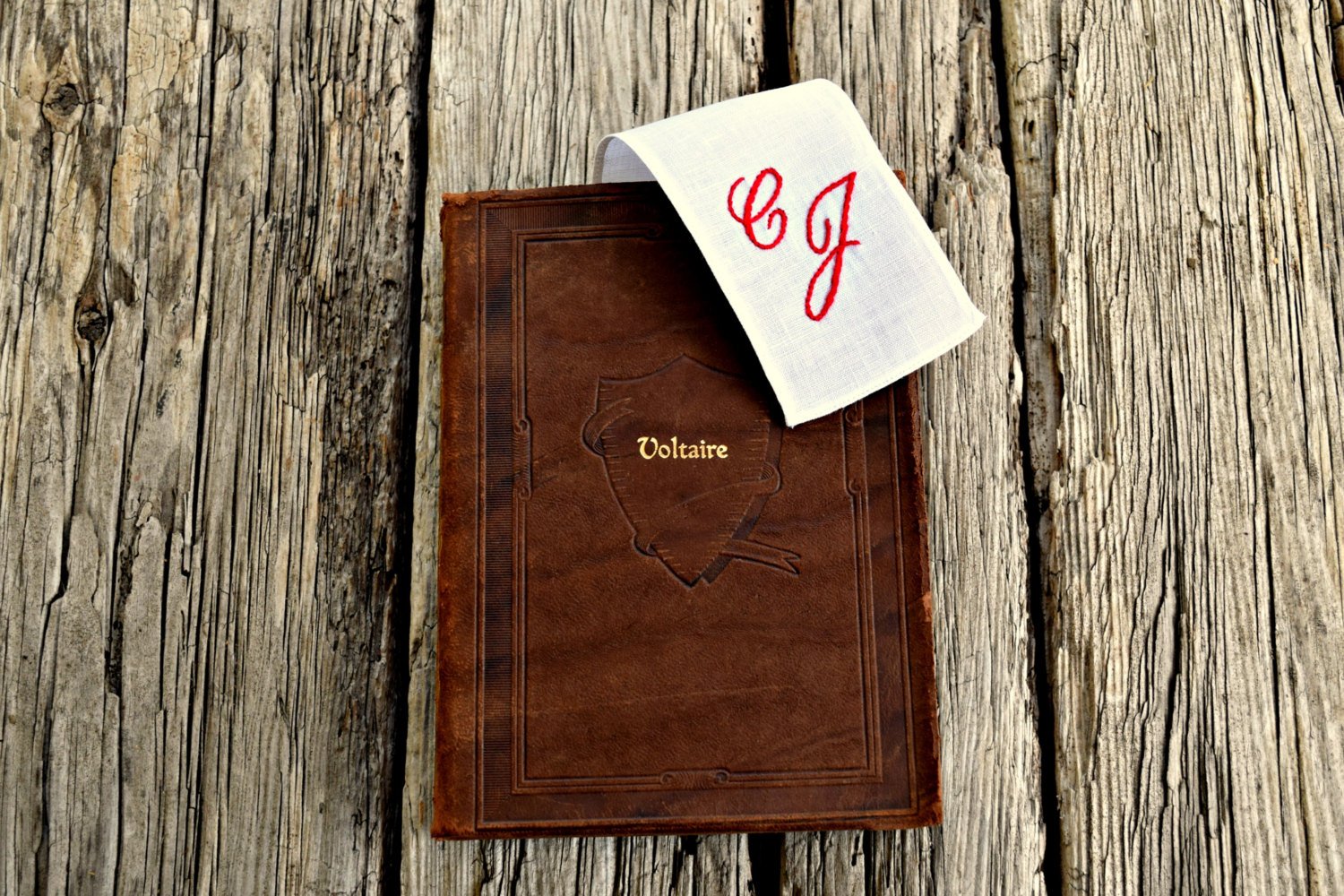 Hand embroidered white linen bookmark with initials extending from book