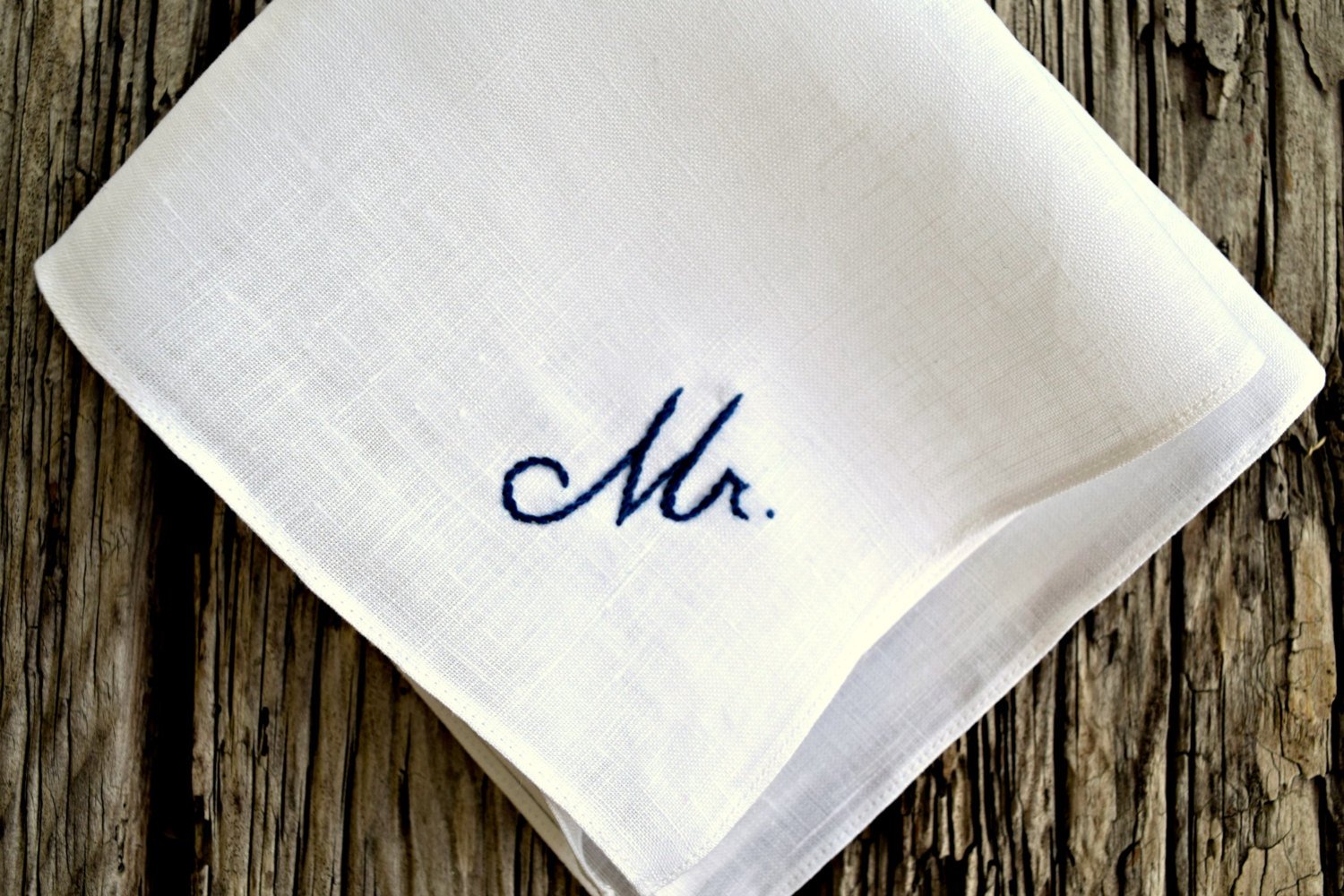 Closeup of hand embroidered pocket square with Mr. design in navy