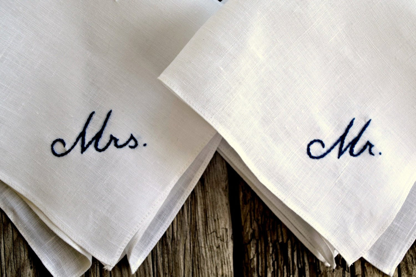 Close up of two handkerchiefs, one hand embroidered Mr. and one Mrs.