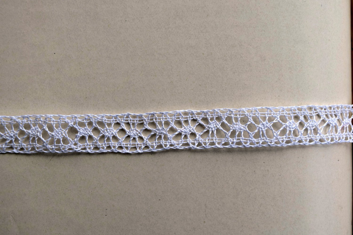 Closeup of handmade bobbin lace showing details of footside and spiders