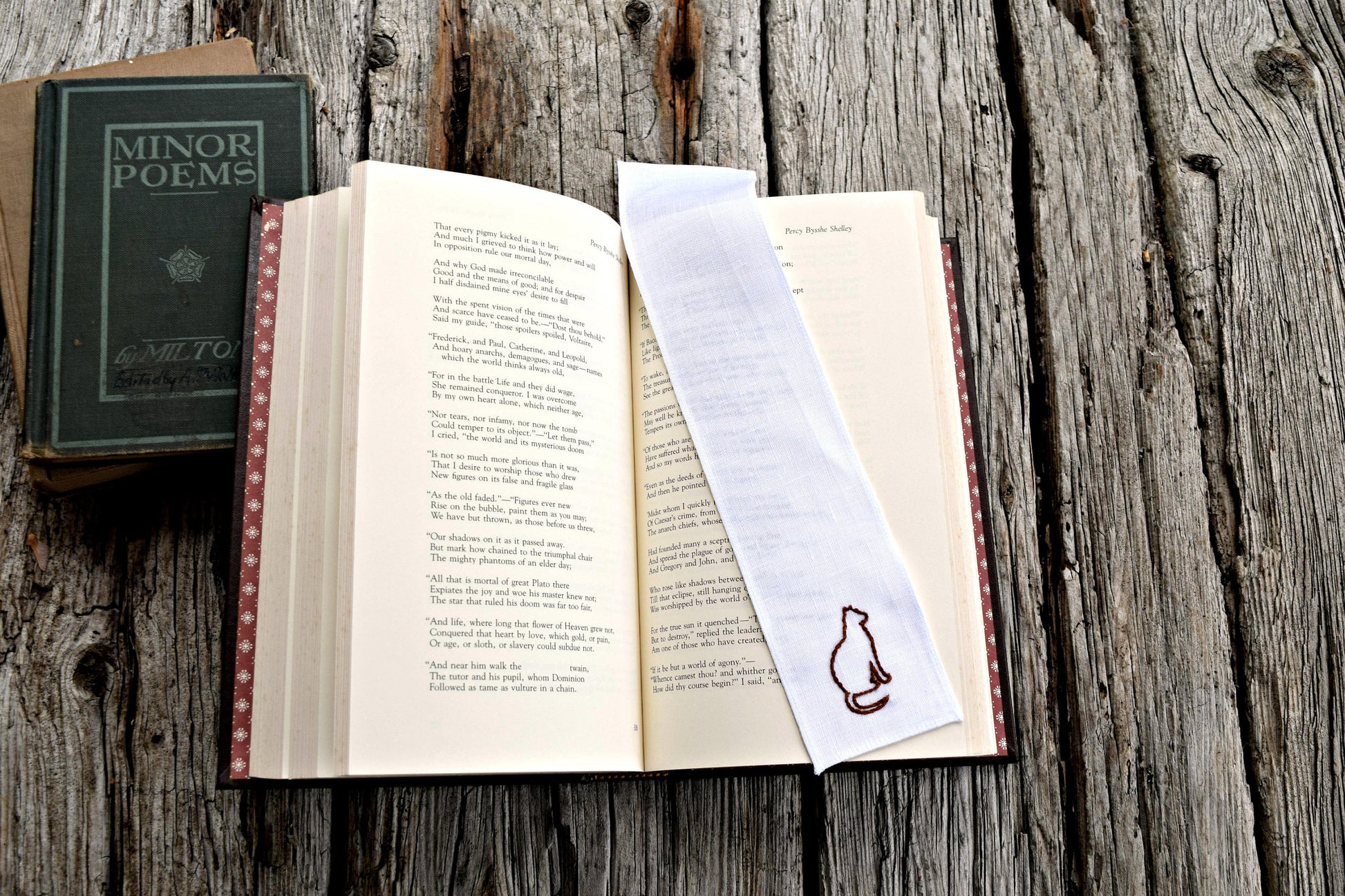 Hand embroidered cat bookmark on open book 