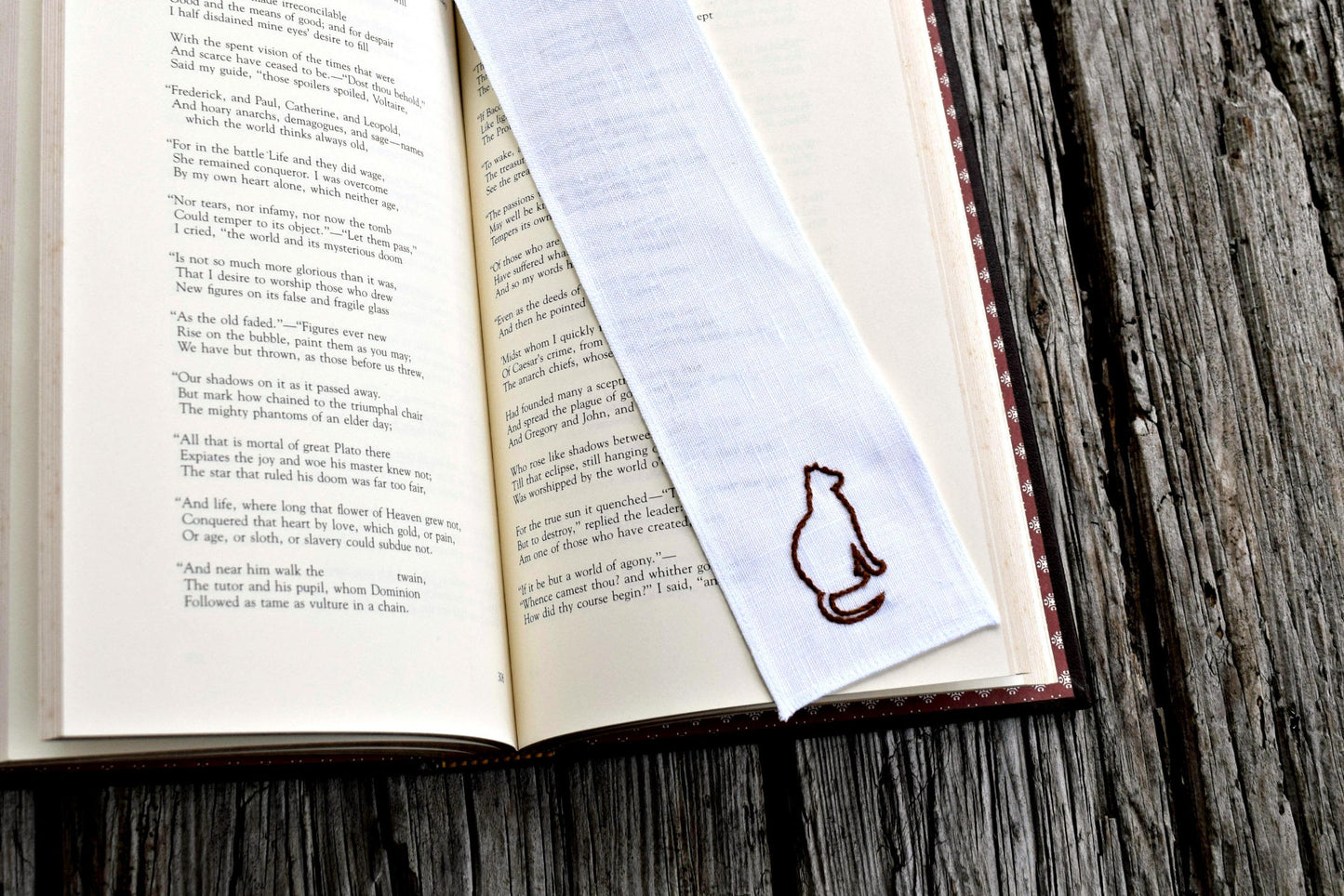 Cat outline hand stitched bookmark on open book 