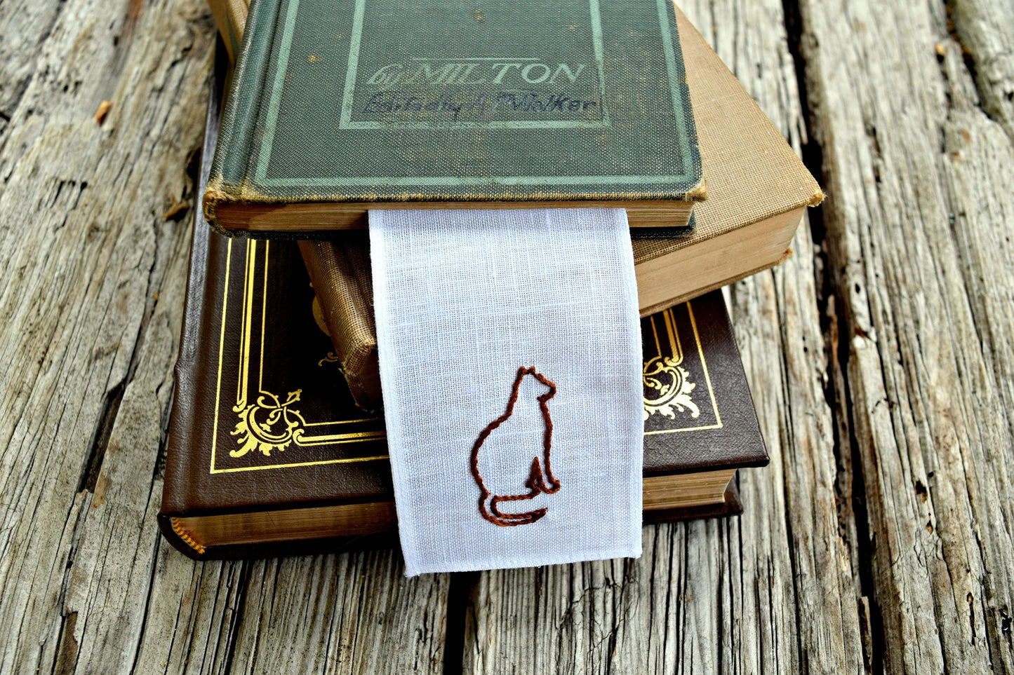 Cat silhouette stitched onto bookmark with volumes of poetry