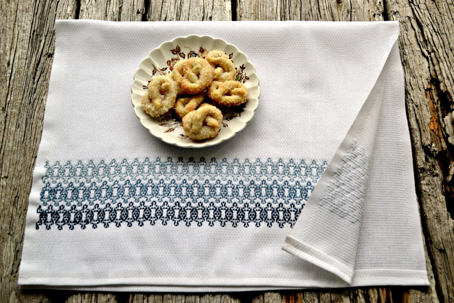 hand embroidered tea towel in geometric pattern with plate of cookies