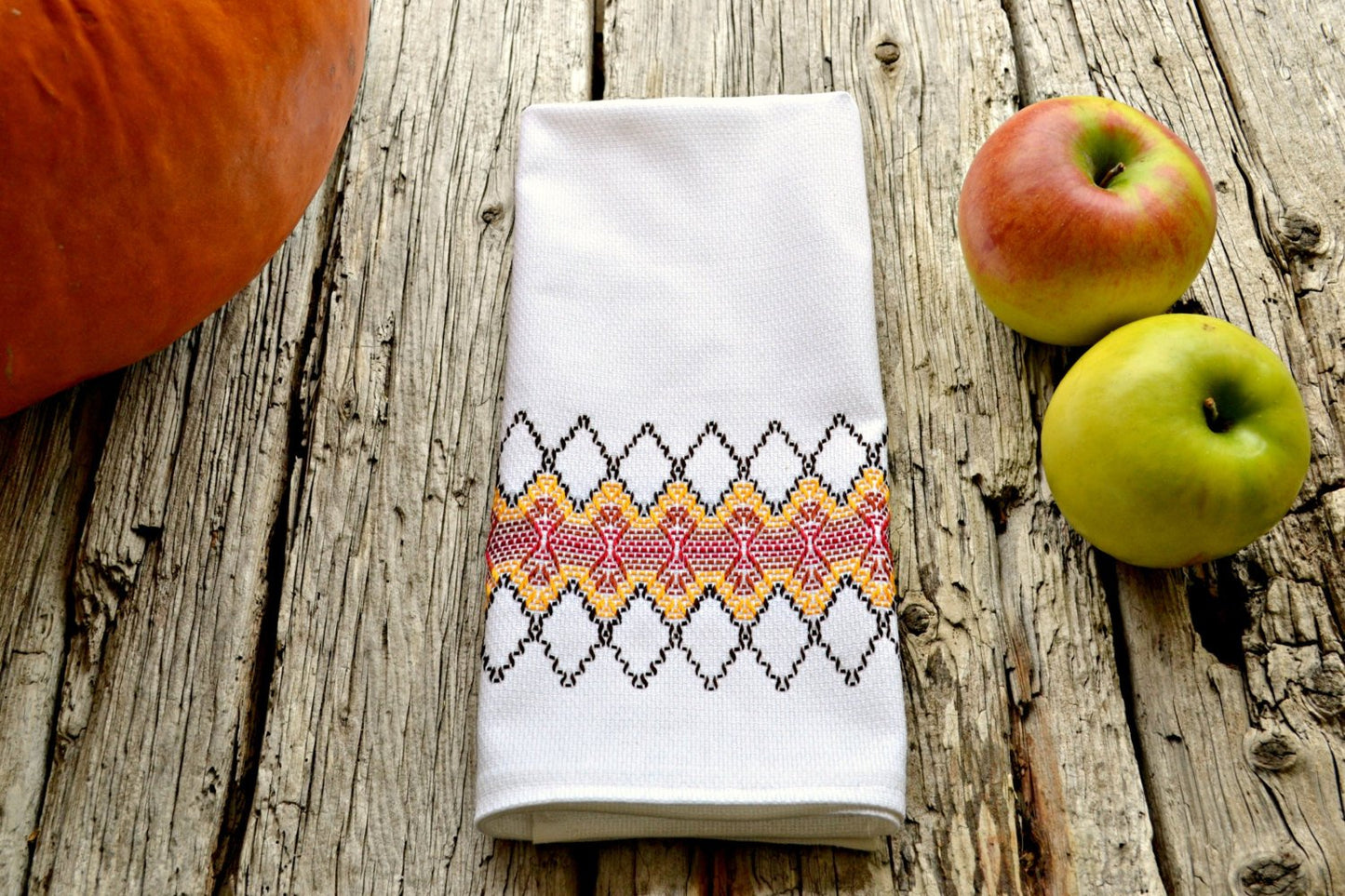Huck teatowel stitched in fall colors with apples and pumpkin