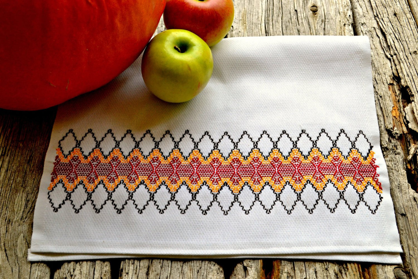 Hand embroidered huck kitchen towel with red and orange diamonds