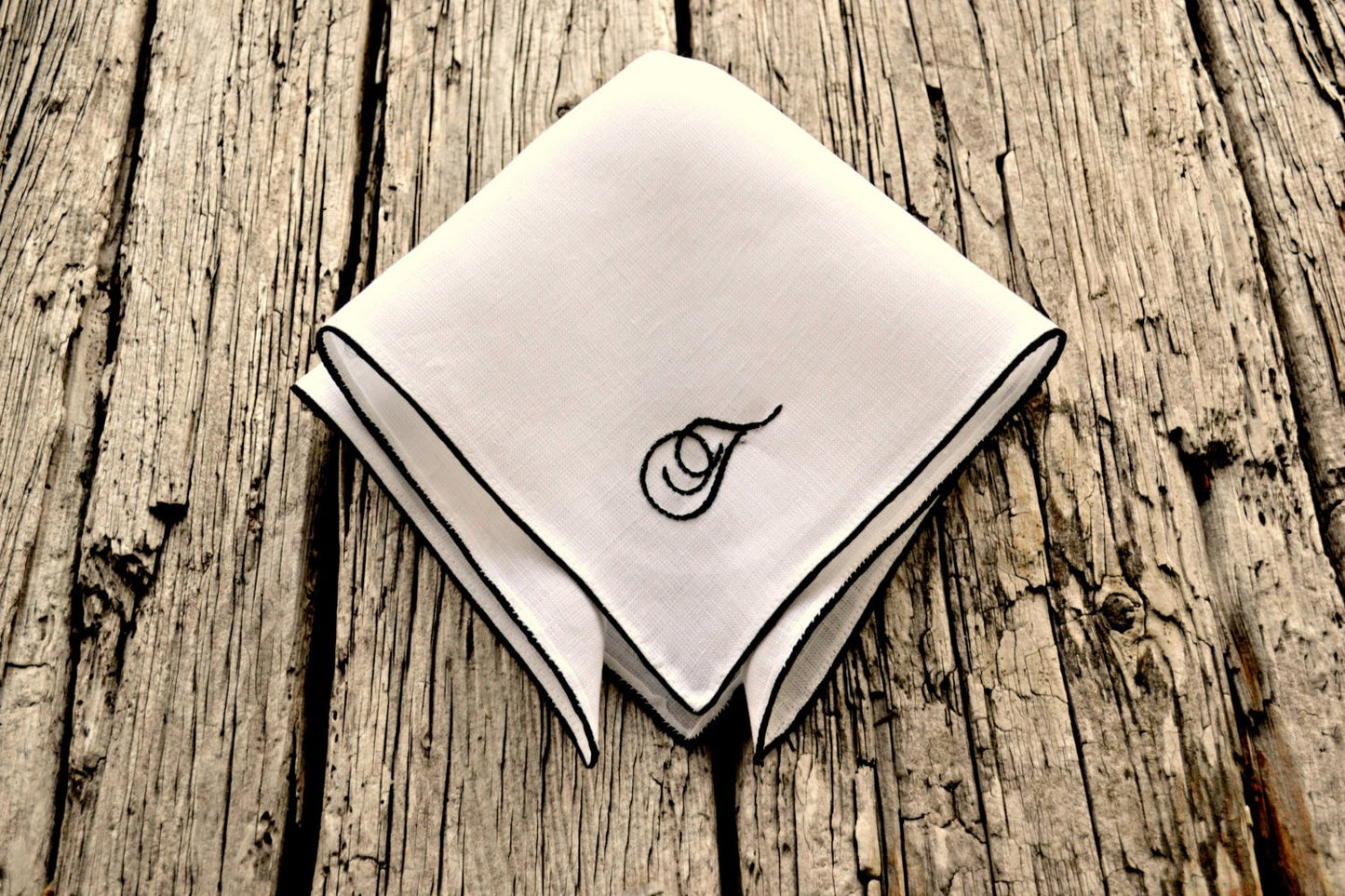 White linen pocket square with satin border in black and script letter T